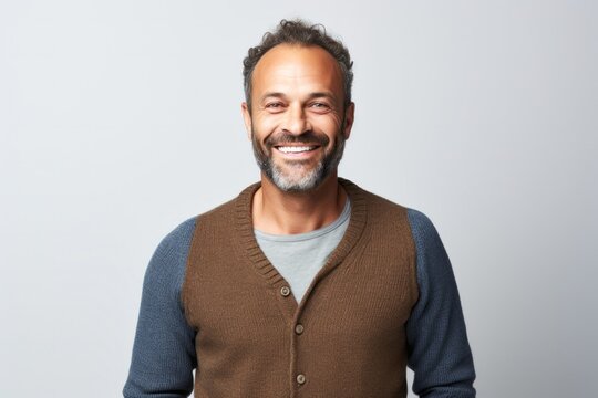 portrait of a happy Israeli man in his 40s wearing a chic cardigan against a white background