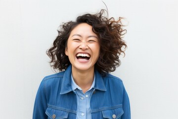 portrait of a happy Japanese woman in her 30s wearing a denim jacket against a white background - obrazy, fototapety, plakaty