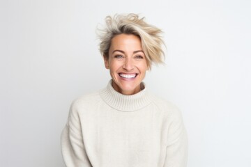 portrait of a happy Polish woman in her 40s wearing a cozy sweater against a white background