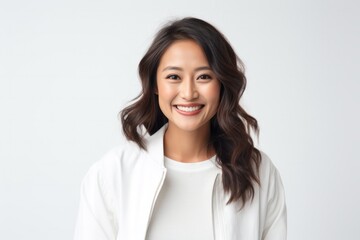 portrait of a happy Filipino woman in her 30s wearing a chic cardigan against a white background