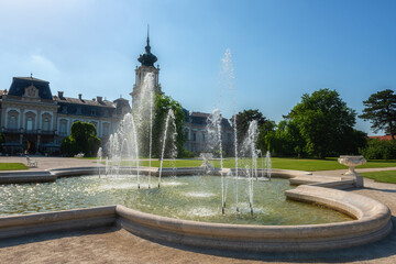 Festetics palace with beautiful garden and exquisite fountain on sunny summer day, baroque architecture, Keszthely, Zala, Hungary. Outdoor travel background
