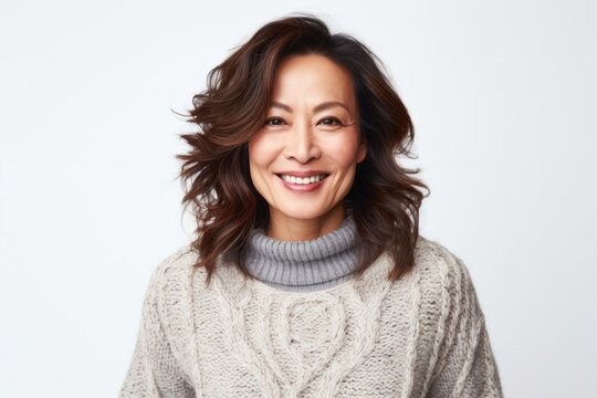 medium shot portrait of a happy Japanese woman in her 40s wearing a cozy sweater against a white background