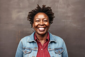 portrait of a happy Kenyan woman in her 40s wearing a denim jacket against a white background - obrazy, fototapety, plakaty