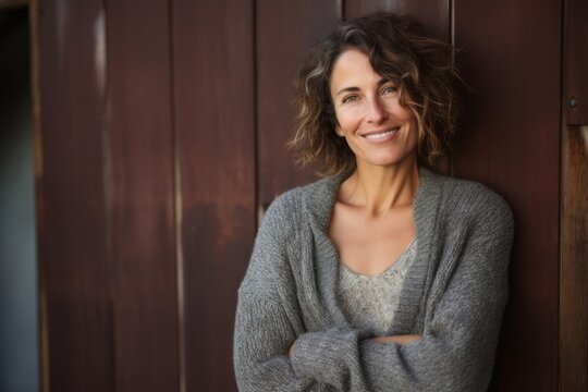 medium shot portrait of a Israeli woman in her 40s wearing a cozy sweater against an abstract background