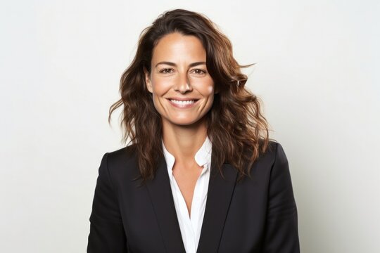 medium shot portrait of a Israeli woman in her 40s wearing a sleek suit against a white background