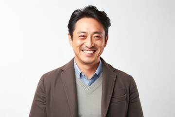 medium shot portrait of a Japanese man in his 40s wearing a chic cardigan against a white background