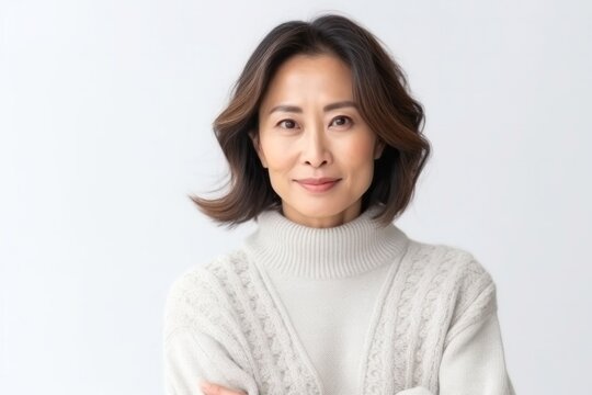 medium shot portrait of a Japanese woman in her 40s wearing a cozy sweater against a white background