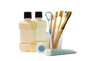 Toothbrush, toothpaste, tongue cleaner and mouthwash in a glass isolated on a white background. A set of toothbrushes in holders. Oral care concept. Dentist concept.