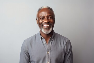 medium shot portrait of a Kenyan man in his 50s wearing a chic cardigan against a minimalist or empty room background - obrazy, fototapety, plakaty