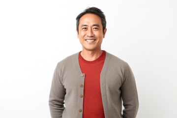 Fototapeta premium portrait of a Filipino man in his 50s wearing a chic cardigan against a white background
