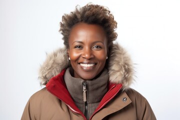 medium shot portrait of a Kenyan woman in her 40s wearing a warm parka against a white background