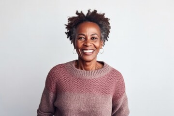 Fototapeta na wymiar medium shot portrait of a Kenyan woman in her 50s wearing a cozy sweater against a minimalist or empty room background