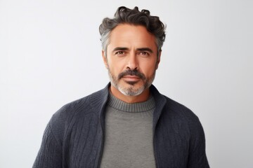 Fototapeta premium medium shot portrait of a Mexican man in his 40s wearing a chic cardigan against a white background