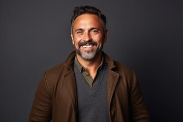 medium shot portrait of a Mexican man in his 40s wearing a chic cardigan against an abstract background