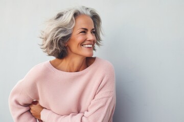portrait of a Israeli woman in her 50s wearing a cozy sweater against a pastel or soft colors...