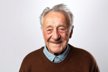 medium shot portrait of a Polish man in his 80s wearing a chic cardigan against a white background
