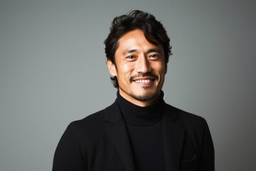 Obraz premium portrait of a Japanese man in his 30s wearing a chic cardigan against a minimalist or empty room background
