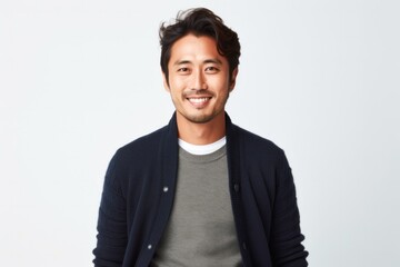 portrait of a Japanese man in his 30s wearing a chic cardigan against a white background