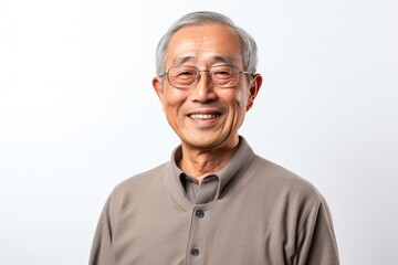 Obraz premium portrait of a Japanese man in his 70s wearing a chic cardigan against a white background