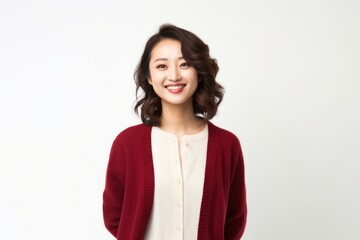 Fototapeta premium portrait of a Japanese woman in her 30s wearing a chic cardigan against a white background