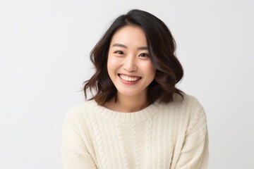 portrait of a Japanese woman in her 30s wearing a cozy sweater against a white background - obrazy, fototapety, plakaty