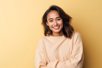 medium shot portrait of a confident Filipino woman in her 30s wearing a cozy sweater against an abstract background