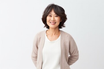 Obraz premium medium shot portrait of a confident Japanese woman in her 50s wearing a chic cardigan against a white background