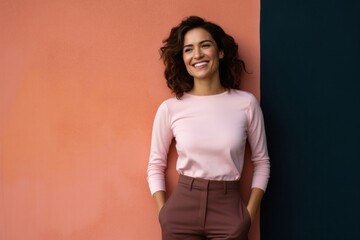 portrait of a Mexican woman in her 30s wearing a smart pair of trousers against an abstract background