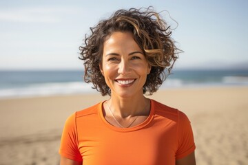 portrait of a Mexican woman in her 40s wearing a sporty polo shirt against a beach background
