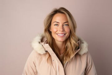 portrait of a Polish woman in her 30s wearing a warm parka against a pastel or soft colors background