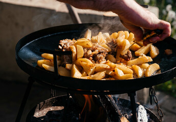 Fried meat and potatoes on a picnic. Cooking outdoors. 
