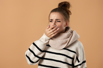 sick woman in sweater coughing covering mouth with hand