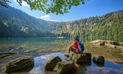 nice senior woman resting during a  mountain bike tour at Lake Feldsee in the  German Black Forest near Titisee-Neustadt, Baden-Württemberg, Germany