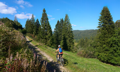 Fototapeta premium nice senior woman on her electric mountain bike cycling in the German Black Forest near Titisee-Neustadt, Baden-Württemberg, Germany