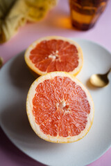 Healthy breakfast or snack with pink grapefruit. Background image with pink and orange tones. Fruit, vitamins, and homemade food.