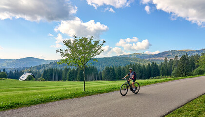 nice senior woman on her electric mountain bike cycling in the German Black Forest below Feldberg summit in Baden-Wuerttemberg, Germany