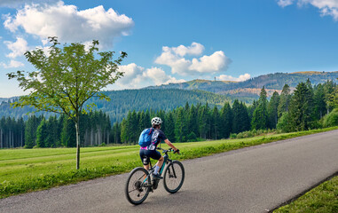 Obraz premium nice senior woman on her electric mountain bike cycling in the German Black Forest below Feldberg summit in Baden-Wuerttemberg, Germany