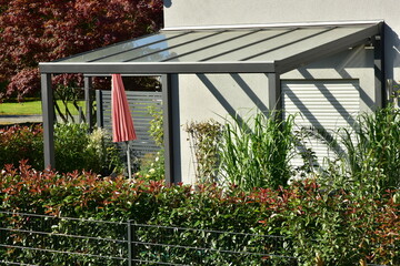 Sonnendach / Pergola als Sonnenschutz auf der Terrasse eines neu gebauten Wohnhauses - obrazy, fototapety, plakaty