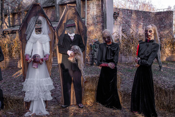 Halloween installation of the bride and groom standing in wooden coffins and holding severed heads...