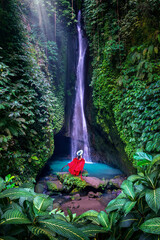 Tourist standing at Leke Leke waterfall in Bali, Indonesia.
