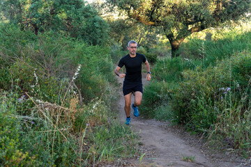 Experienced trail runner with gray hair and sleek black gear, conquering rugged terrain.