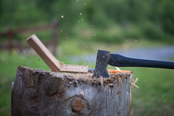 Axe splitting wood with flying splinters and wood dust