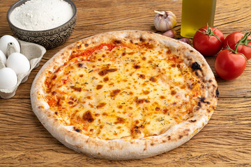 Mozzarella cheese pizza with tomatoes, eggs and flour over wooden table