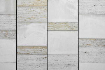 White marble granite wall. The facing facade of the building as a background of natural stone.