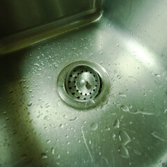 Typical American brushed stainless-steel tub sink with perforated disposal strainer basket