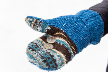 A glove holding two US quarter Dollars with white snow in the background. Financial concept with snow, exceeding heating and gas prices.