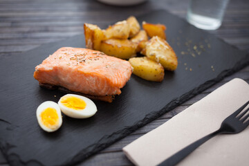 Steamed salmon fillet with potato wedges and quail egg