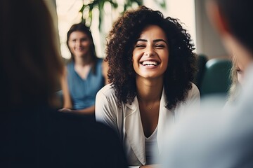Group therapy and support. The focus is on a young African American woman. A group of people around support her. She is happy.