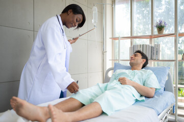 Doctor talking something with patient while lying-in on the bed in the hospital