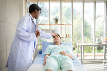 Doctor talking something with patient while lying-in on the bed in the hospital